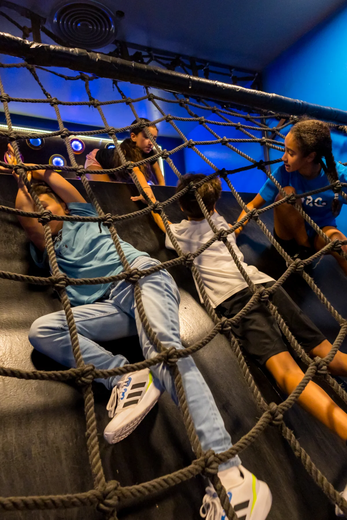 Students climbing through the rope net challenge on a school trip in Dubai